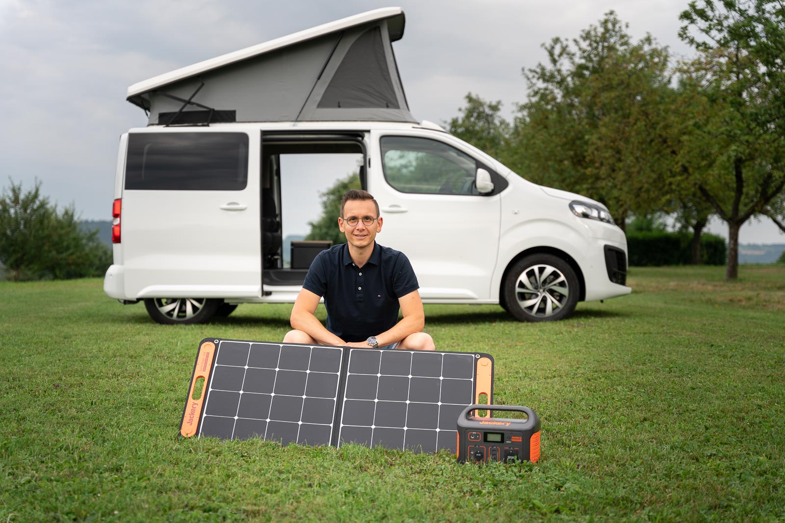 Solarmodul und Batterie vor einem Camper Van